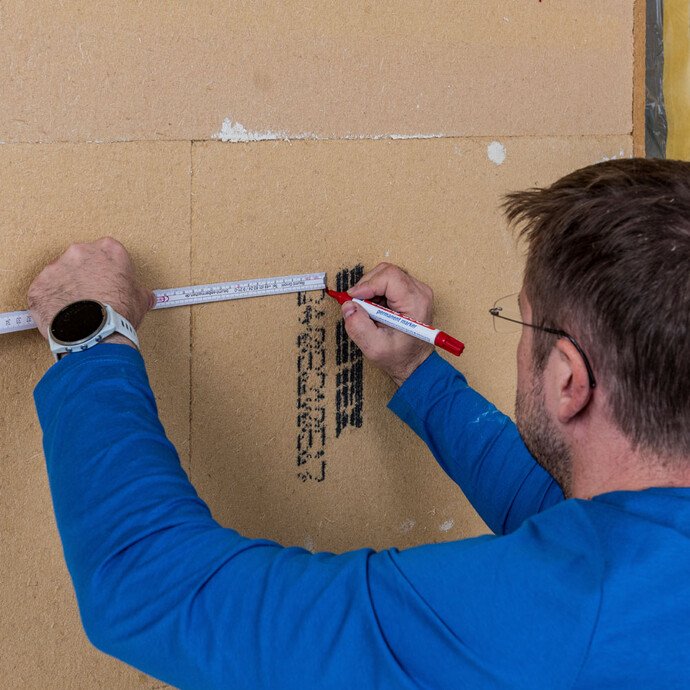 Die Position der Schraubdübel Thermotop S1 short werden als erstes auf der Innendämmung mit Holzfaser markiert.