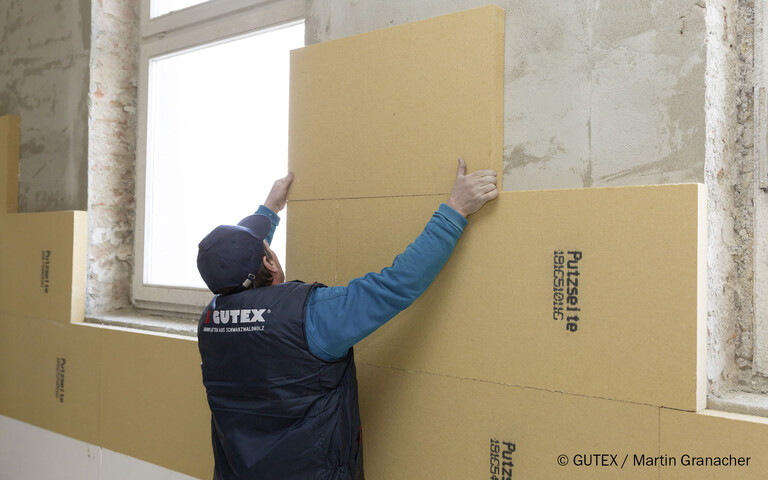 Die Holzfaserdämmplatte Thermoroom von GUTEX wird als Innendämmung auf das Mauerwerk geklebt.