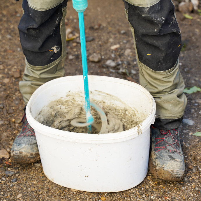 Rühre mit einem elektrischen Rührwerk die Baumit Dichtschlämme flexibel mit Wasser an, bis eine gleichmäßige Konsistenz erreicht ist.